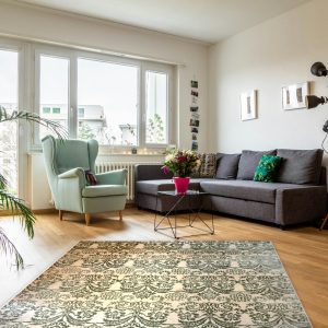 Tappeto moderno orientale annodato a mano 247×200 cm, damascato verde salvia su fondo avorio, ambientato in un soggiorno luminoso con parquet