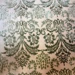 Dettaglio del disegno damascato in rilievo: motivi in seta verde salvia su fondo in lana avorio